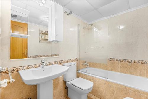 een badkamer met toilet, wastafel en bad bij Yovalutres Piscina Privada Torrevi in Torrevieja