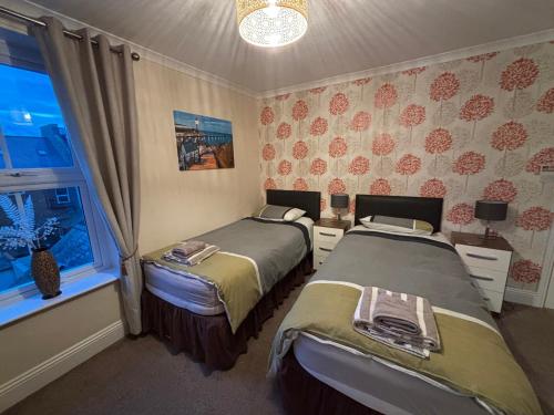 a bedroom with two beds and a window at The Lansbury - Whitby in Whitby