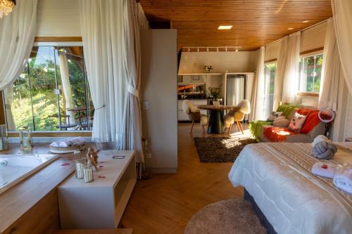 a bedroom with a large bed and a bath tub at Pousada São Gabriel in Barracão