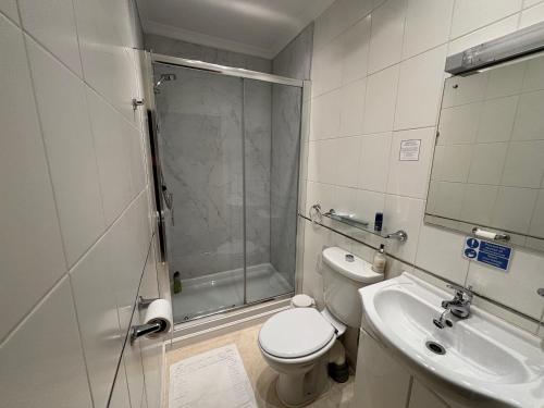 a bathroom with a shower and a toilet and a sink at The Lansbury - Whitby in Whitby