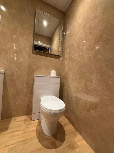 a bathroom with a white toilet and a mirror at The Lansbury - Whitby in Whitby
