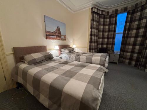 a hotel room with two beds and two windows at The Lansbury - Whitby in Whitby