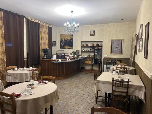 un restaurant avec deux tables et un comptoir dans une salle dans l'établissement Hotel De La Loire, à Saint-Satur