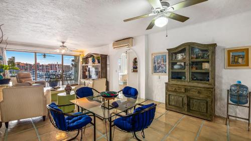 プエルト・バジャルタにある2BR Marina Condoのリビングルーム(ダイニングルームテーブル、青い椅子付)