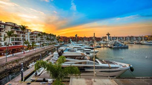 a group of boats docked in a marina at sunset at 2BR Marina Condo in Puerto Vallarta