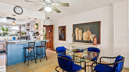 a kitchen with blue bar stools and a clock on the wall at 2BR Marina Condo in Puerto Vallarta