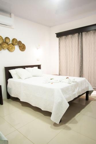 a bedroom with a large white bed with white sheets at Casa DesKanso - La Fortuna in Fortuna