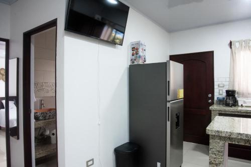 a kitchen with a black refrigerator in a room at Casa DesKanso - La Fortuna in Fortuna