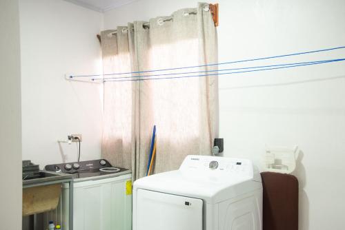 a kitchen with a washing machine and a curtain at Casa DesKanso - La Fortuna in Fortuna