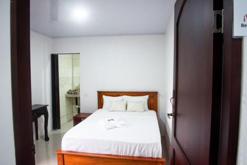 a bedroom with a bed with white sheets at Casa DesKanso - La Fortuna in Fortuna