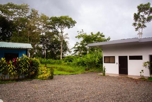 a small white house with a blue building at Casa DesKanso - La Fortuna in Fortuna