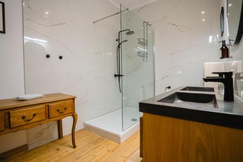 a bathroom with a glass shower and a sink at Circa 1929 in Ostend