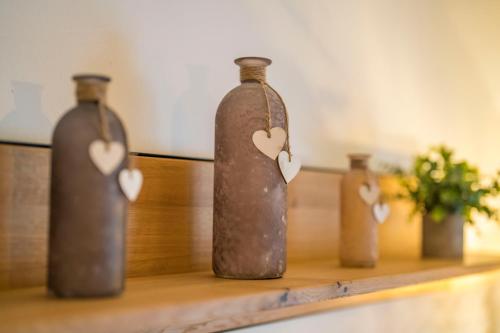 three bottles with hearts on them sitting on a shelf at Ferienwohnung Andexlinger in Abtenau