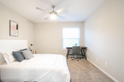 ein weißes Schlafzimmer mit einem Bett und einem Schreibtisch in der Unterkunft Halsten at Vinings 3406 Spacious 1 Bed 1 Bath in Atlanta