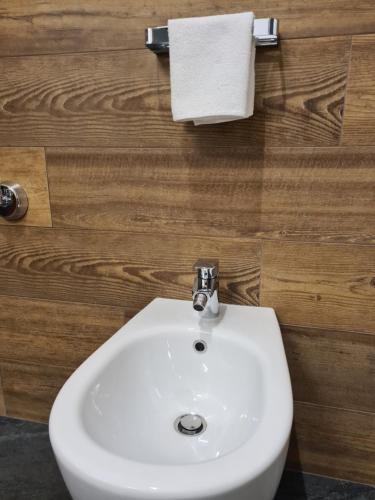 a white sink in a bathroom with a wooden wall at La Villetta di Oulx in Oulx