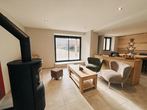 un salon avec un poêle à bois dans une pièce dans l'établissement Côté Montagne, à Giron