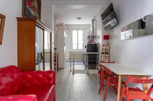 un salon avec un canapé rouge et une table dans l'établissement Duplex and private patio at Eiffel Tower, à Paris