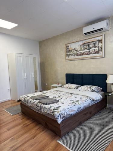 a bedroom with a large bed with a blue headboard at habitat Heart of Ruse Apartment in Ruse