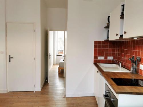 une cuisine avec un évier et un plan de travail dans l'établissement L'Orangeade, à Cognac