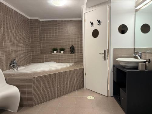 a bathroom with a tub and a sink at Luxury StudioArchit 7 & jacuzzi suite in Patra