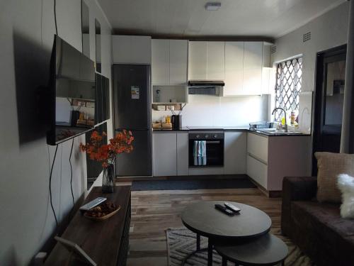 a small kitchen and living room with a couch and a table at Rena Apartments in Lilongwe
