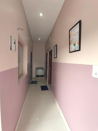 an empty hallway with pink walls and white floors at Nutan Homestay in Deoghar