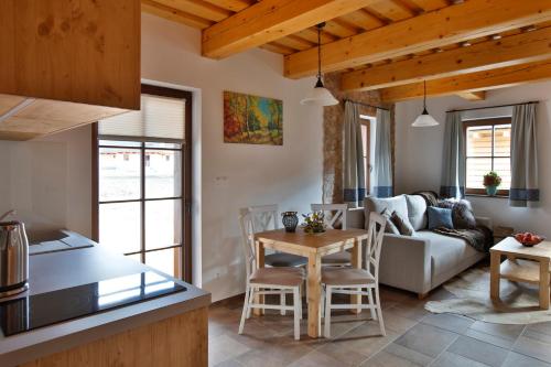 a kitchen and living room with a table and a couch at Zaži Chalupa Liptovska Osada in Liptovská Osada