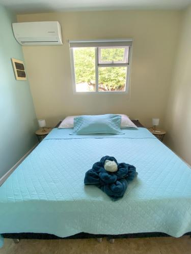 a bedroom with a blue bed with a clock on it at Pura Vida Aruba appartement Cama in Noord