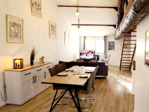 une salle à manger et un salon avec une table et des chaises dans l'établissement Le Marceau Terrasse Sur Le Toit, à Narbonne