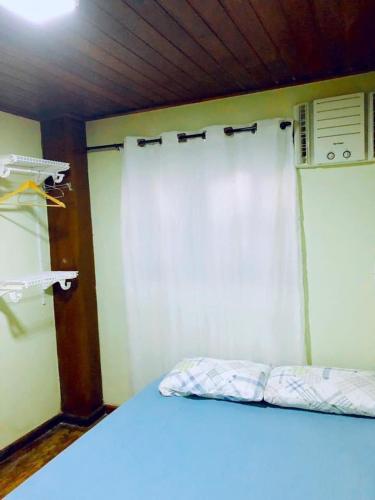 a bed in a room with a white curtain at Sobrado em Javary - 1 km do Lago in Miguel Pereira