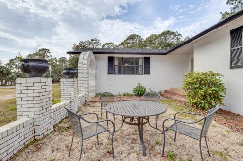 a patio with a table and chairs in front of a house at Steps to Beach Carrabelle Family Home with Patio! in Big Blackjack Landing