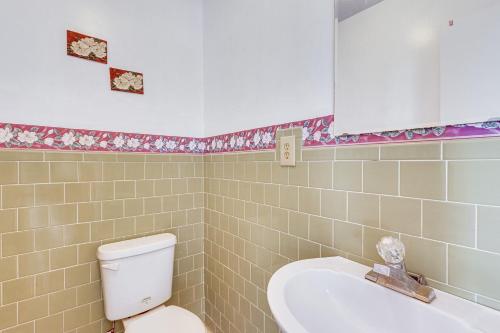 a bathroom with a toilet and a sink and a mirror at Steps to Beach Carrabelle Family Home with Patio! in Big Blackjack Landing