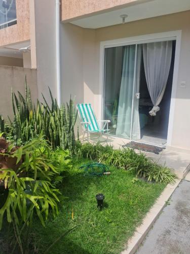 a house with a lawn with a chair and a window at Lar Suave Lar in Florianópolis