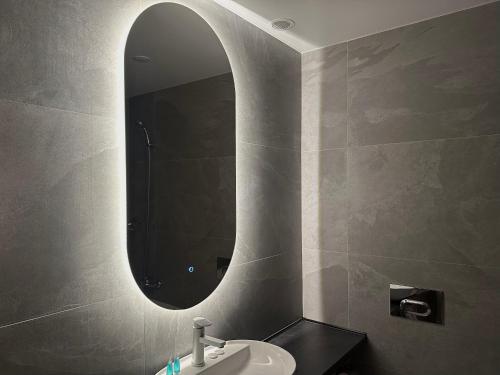 a bathroom with a sink and a mirror at Eastwood Hotel & Resort in Semey