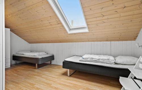 two beds in a room with a wooden ceiling at 4 Bedroom Cozy Home In Ans By in Roe