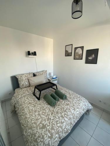 a bedroom with a bed with a table on it at Appartement 2 pièces avec Projecteur à 100m du métro in Saint-Ouen