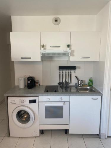 une cuisine avec une machine à laver et un évier dans l'établissement Appartement 2 pièces avec Projecteur à 100m du métro, à Saint-Ouen