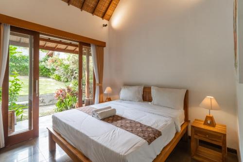 チャングーにあるJinar Guest Houseのベッドと大きな窓のある寝室