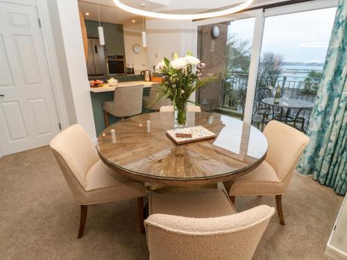a dining room with a wooden table and chairs at Fal View in Falmouth