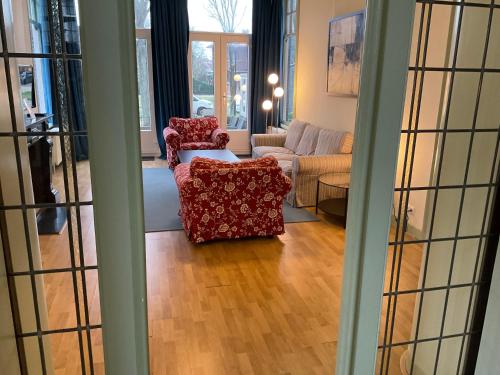 a living room with two chairs and a couch at Multatuli House by Hofstad Studios in Scheveningen