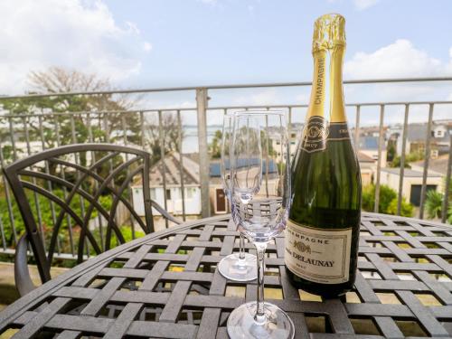 a bottle of champagne and two glasses on a table at Fal View in Falmouth