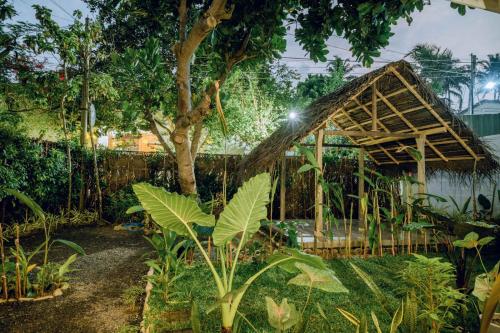 a greenhouse in a garden with a tree at CosyNsurf in Matara