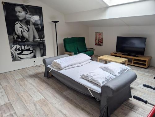 une chambre avec un lit et une télévision à écran plat dans l'établissement Maison en pierres, à Fontanès