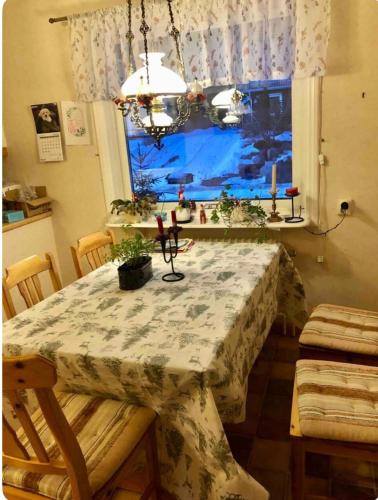 a dining room table with a tablecloth on it with a window at Cozy room surrounded by nature in Falun
