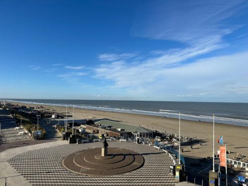 vistas a una playa con el océano y reloj en Blue Bay Zandvoort, en Zandvoort