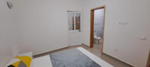 a white bathroom with a toilet and a mirror at Maravilha do Planalto in Assomada