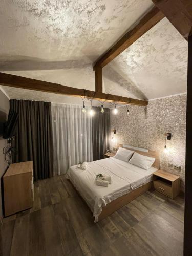 a bedroom with a large bed in a room at Къща за гости Гардения in Kamburovo