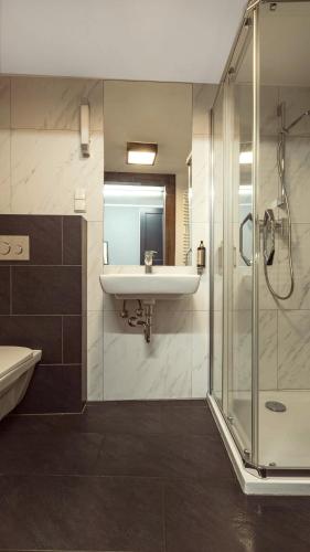 a bathroom with a sink and a shower at Jana Apartment in Krakow