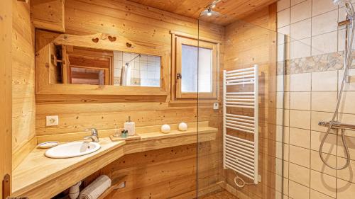 une salle de bain avec un lavabo et une douche en verre dans l'établissement Le Refuge Alpin, au Grand-Bornand