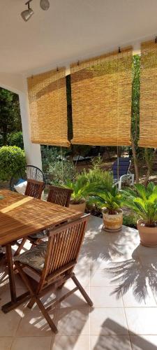 a patio with a wooden table and chairs at Ana in Premantura